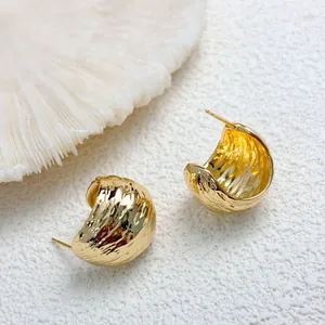 Macro view of 18K gold plated pleated geometric earrings with unique textured finish