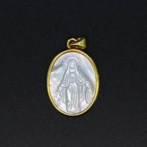 Macro detail of an oval natural mother of pearl pendant with religious figure carving