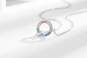 Elegante zilverkleurige ketting met een dubbele ring hanger en regenboog kristallen
