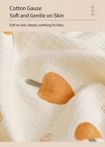 Gros plan d'une couverture pour bébé en gaze de coton à 4 couches avec motif de feuilles