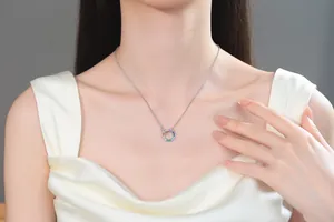 Close-up van elegante zilveren ketting met regenboog strass cirkelhanger op een model