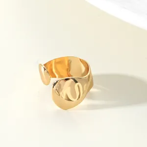 Detailed macro view of a minimalist gold teardrop wrap ring with a polished finish