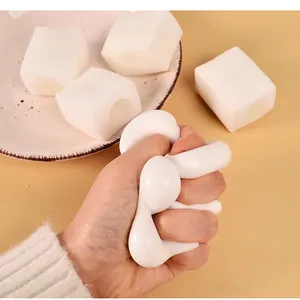 Hand drückt ein weiches weißes Tofu-Squishy-Spielzeug für effektiven Stressabbau und Spaß.
