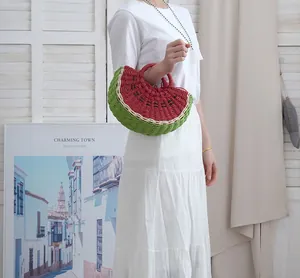 Detalle de un bolso de mano de paja trenzado con forma de sandía para ir a la playa