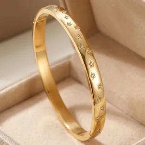 Detail view of a luxury 18K gold plated titanium steel bangle with star-shaped zircon