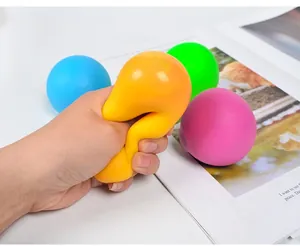 Hand drückt gelben TPR-Stressball, um Flexibilität und langsamen Rückpralleffekt zu zeigen.