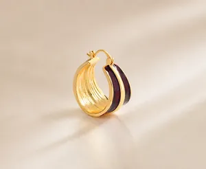 Dettaglio di orecchini a cerchio in smalto bordeaux con placcatura oro 22K e misura 26mm