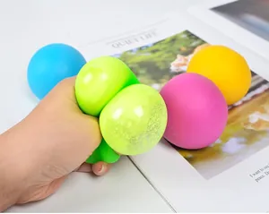 Hand drückt einen limettengrünen TPR-Stressball mit bunten, weichen Mehlbällen.