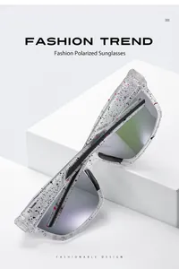 Close-up of polarized sunglasses with unique black and pink splatter pattern frame