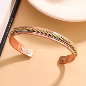 Detailweergave van een vintage koperen magneetarmband met gedraaid vlechtontwerp.