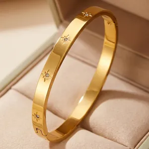 Detailed view of 18K gold-plated titanium steel bangle with engraved star patterns