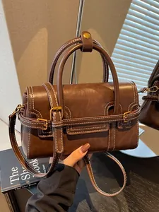 Vintage brown leather top-handle square bag with white stitching and crossbody strap