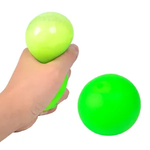 Nahaufnahme einer Hand, die einen grünen TPR-Anti-Stress-Ball mit Langsamrückfederung drückt