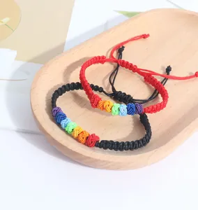 Macro detail view of handmade rainbow knot woven bracelets in red and black colors.