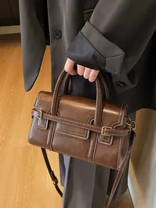 Vintage brown leather crossbody bag with white stitching and gold hardware details.