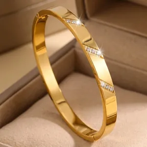 Macro detail of luxury 18K gold plated titanium steel bangle with inlaid crystals