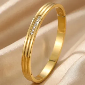 Detail view of gold-plated ridged stainless steel bangle with sparkling CZ stones