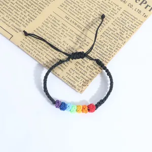 Close-up of handmade rainbow knot woven bracelet with adjustable black rope design