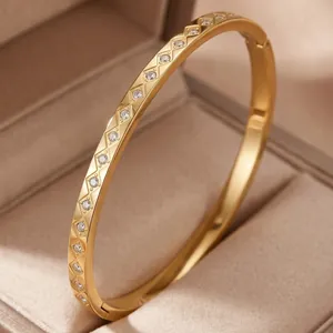 Close-up of 18K gold plated bangle with geometric diamond pattern and clear stones