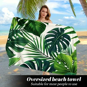 Telo mare in microfibra con stampa di foglie di monstera in un ambiente tropicale.