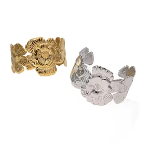 Macro view of gold and silver vintage floral stainless steel cuff bracelets