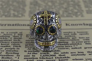Vue détaillée d'une bague crâne punk vintage en acier titane avec des yeux en pierre verte