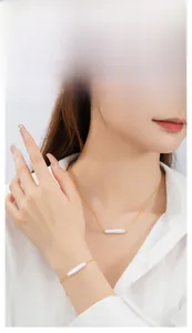 Elegant baroque pearl necklace and bracelet set styled on a model with a white shirt.