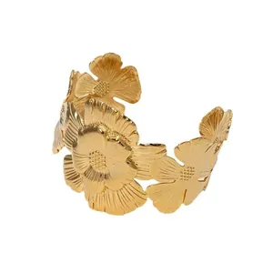 Detailed close-up of a vintage oversized floral gold cuff bracelet with textured petals.