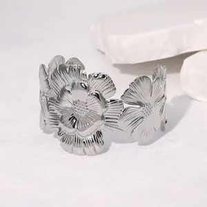 Detail view of a silver floral stainless steel cuff bracelet with intricate petal textures