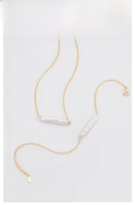 Detailed shot of gold-plated 925 silver necklace featuring elegant baroque pearls.