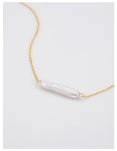 Detailed macro view of an elegant long baroque pearl pendant on a gold sterling silver chain