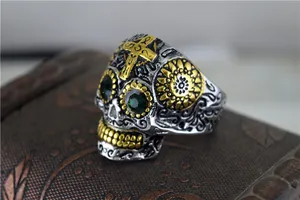Macro détaillée d'une bague tête de mort gothique en acier titane avec yeux verts