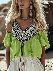 Detail of lime green cold shoulder top with intricate bohemian print and V-neckline