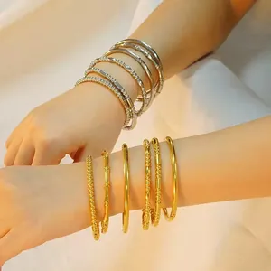 Conjunto de brazaletes de acero inoxidable dorados y plateados para mujer en muñeca