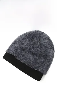 Close-up of a grey fuzzy knit beanie with a black ribbed cuff, perfect for winter outdoor warmth.