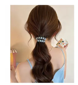 Vue de dos d'une femme portant un élastique à cheveux spirale bleu clair en queue de cheval