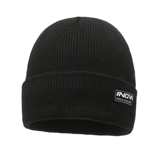 Classic black rib-knit winter beanie hat with stylish brand patch on folded cuff.