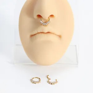 Detailansicht eines goldenen Titan Septum Clicker Rings mit weißen Zirkonia am Modell
