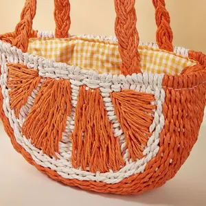 Vista macro dettagliata di borsa in paglia a forma di arancia con fodera vichy gialla