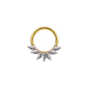 Nahaufnahme goldener Titan-Piercingring mit fünf weißen Zirkonia im Marquise-Schliff