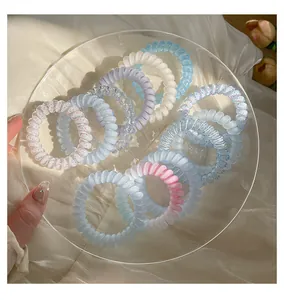 Vue détaillée de chouchous colorés en fil de téléphone sur une assiette en verre.