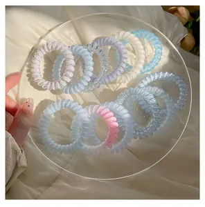 Détail d'élastiques à cheveux en spirale pastel au design de fil de téléphone élastique.