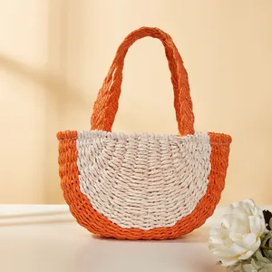 Vista dettagliata di una borsa a mano in paglia intrecciata arancione e bianca per bambini.