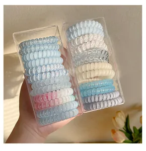 Gros plan de divers élastiques spirale colorés dans des boîtes sous une lumière chaude.