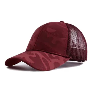 Detail view of a burgundy camouflage mesh baseball cap featuring a breathable texture