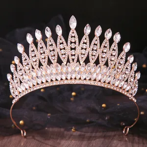Intricate gold bridal tiara with sparkling marquise and round rhinestones on black lace background