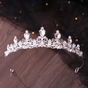 Close-up of silver bridal tiara with sparkling crystal rhinestones on dark wood background