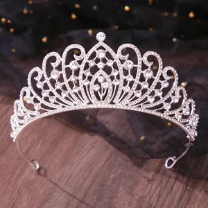 Detailed shot of a silver bridal rhinestone tiara with elegant curved patterns and clear crystals.
