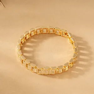 Macro detail of a luxurious gold-plated copper watch link bracelet set with sparkling cubic zirconia