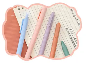 Close-up detail of minimalist retractable gel pens in soft Morandi colors on a notebook